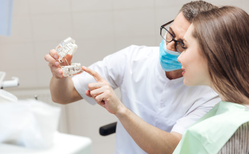 orthodontist showing a patient dentures