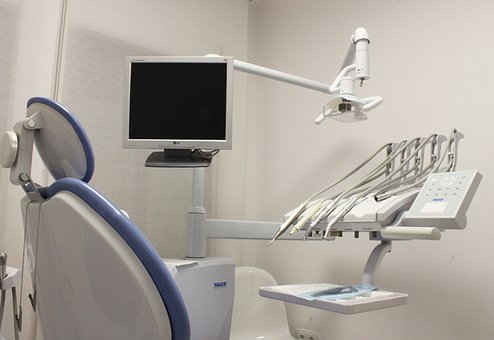 orthodontist chair with tools and a tv