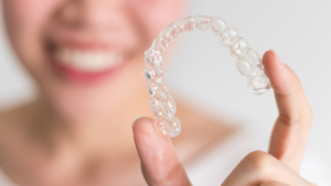 woman holding her orthodontic treatment invisalign tray